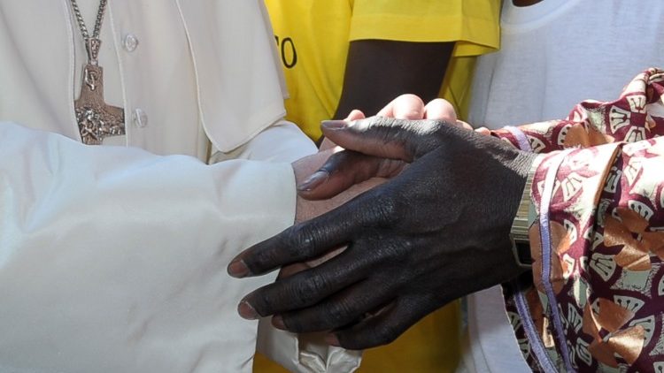 Pope Francis greeting a migrant on his first visit to the island of Lampedusa