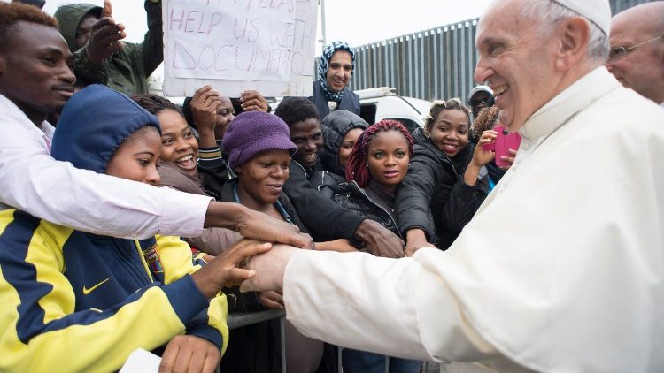 Papa Francesco saluta un gruppo di migranti (foto di archivio)