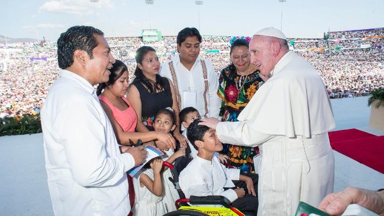 Pope Francis speaks to a family