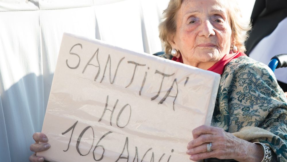 Bei einem von Papst Franziskus angeregten Generationen-Dialog 2018 hält eine Frau ein Schild mit den Worten:  „Heiliger Vater, ich bin 106 Jahre alt"