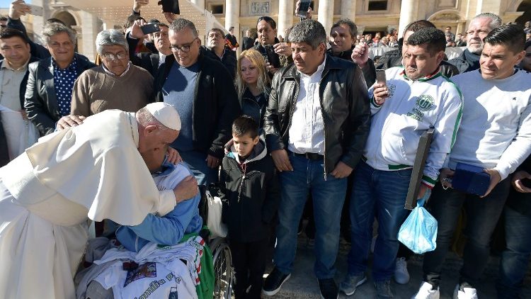 Pope Francis blessing a sick person.