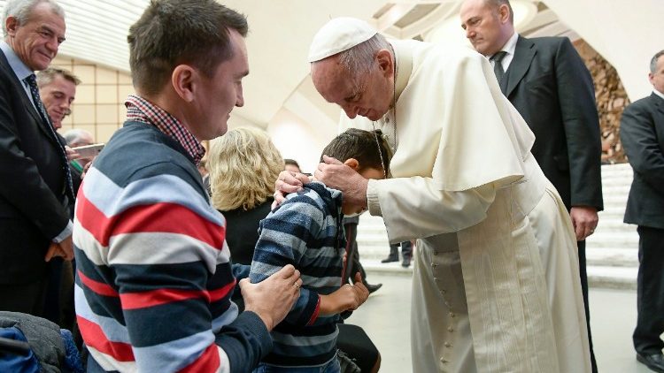 Pope Francis embraces a child