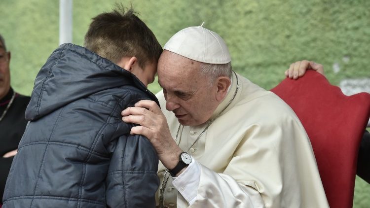Pope Francis listens to a young boy during his parish visit on Sunday