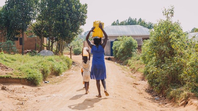 यूगांडा में पाने का पानी ले जाते लोग