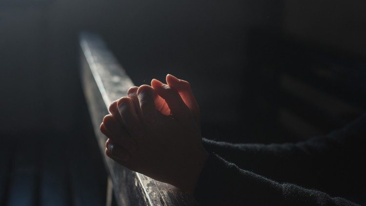 Händer knäppta i bön
