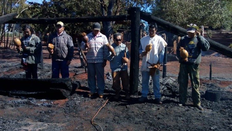 Indígenas oram em meio às cinzas do incêndio que destruiu a casa de reza