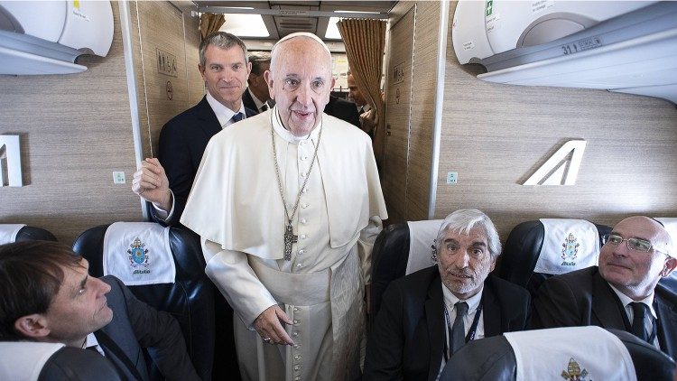 Vatikan-Pressesprecher Matteo Bruni (links hinter Papst Franziskus) im Papstflieger 2018 