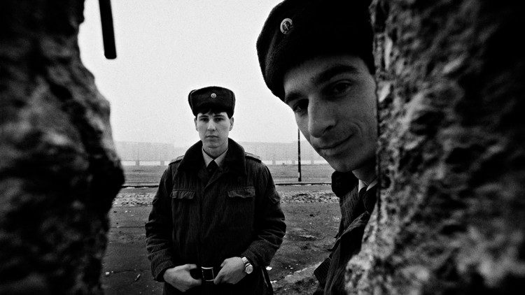I "Vopos", le temibili guardie di confine della DDR, sorridono attraverso una breccia nel Muro, foto di Livio Senigalliesi