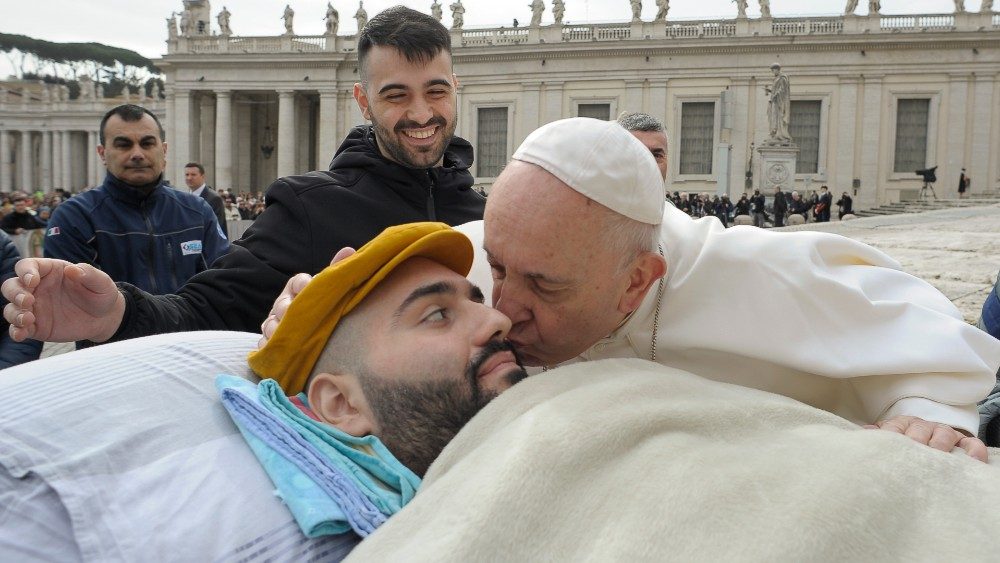 Papa Francesco bacia Paolo Palumbo, il giovane malato di Sla, dietro di lui il fratello Rosario