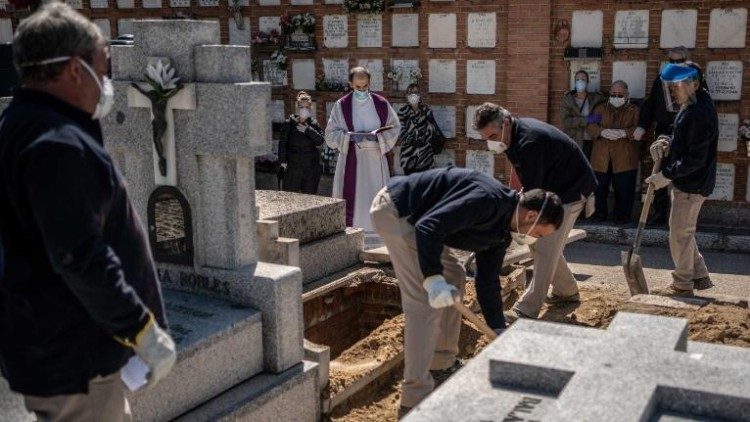 Un sacerdote y los familiares de una víctima mortal de covid-19 llevan a cabo una ceremonia fúnebre en el cementerio de La Almudena, en Madrid, España, el 28 de marzo de 2020. (Crédito: AP Photo/Olmo Calvo).