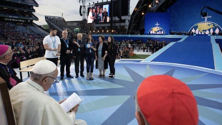 Papa Francesco sfoglia la copia del libro su don Ragheed, durante l'Incontro mondiale delle famiglie di Dublino agosto 2018. Sullo sfondo, la famiglia del sacerdote