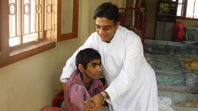 Fr William helps a Dar-ul-Sukun resident in 2005
