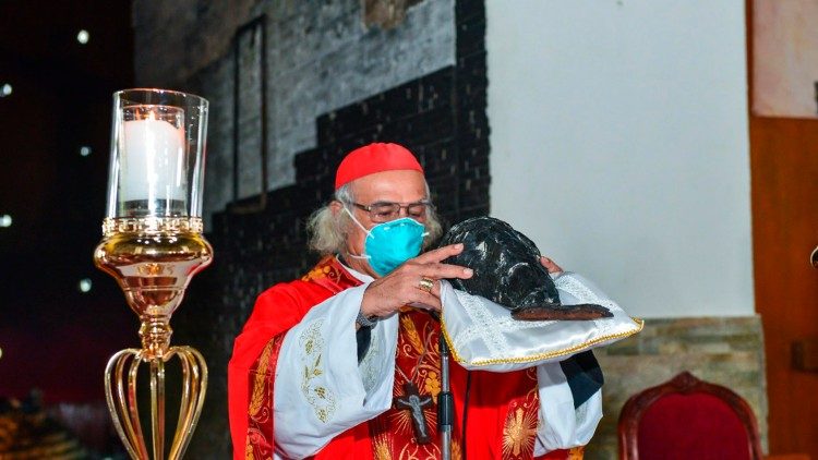 Le cardinal Brenes tenant la tête du crucifix du Sang du Christ, mutilé et carbonisé par un cocktail molotov