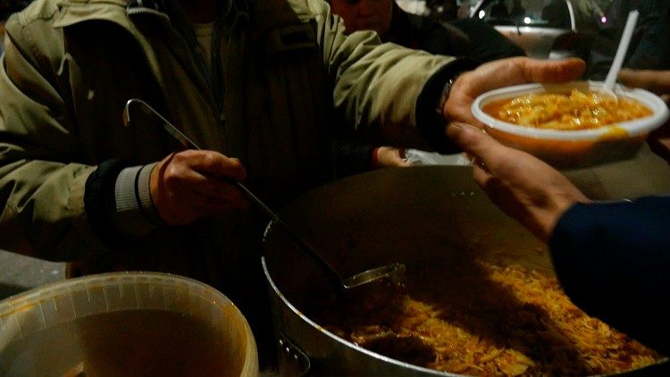 Доброволец раздава храна на бедни по време на пандемията
