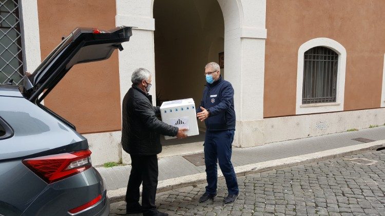 Kardinal Konrad Krajewski übergibt die PCR-Tests einem Mitarbeiter des vatikanischen Gesundheitsamtes