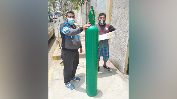 Angehörige eines Covid-Patienten mit Sauerstoffflaschen in Peru