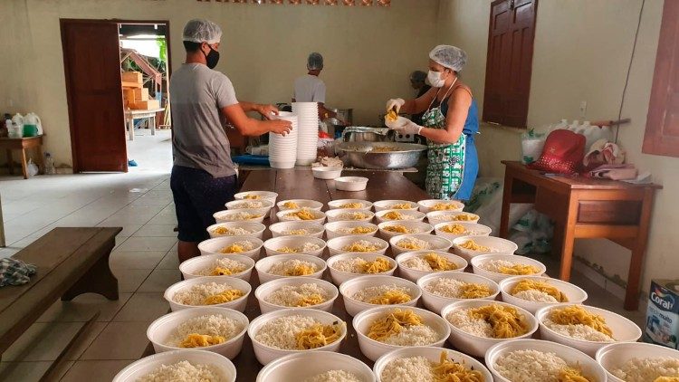 Os voluntários preparam as refeições com as doações