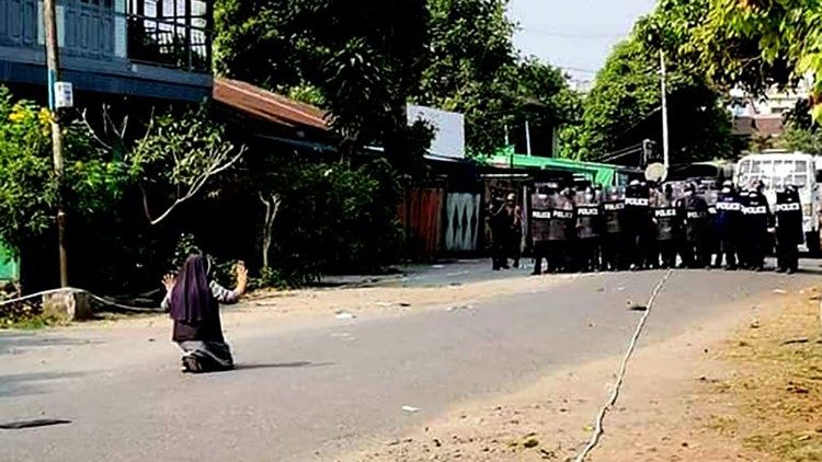 S. Rose Lasang Nu Tawng klūpo gatvėje priešais ginkluotus kareivius