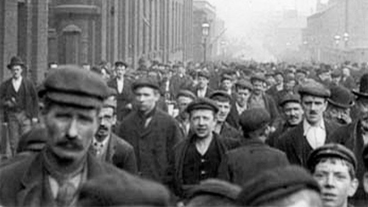 Tra la folla, volti di operai e lavoratori in una foto dell'anno 1900