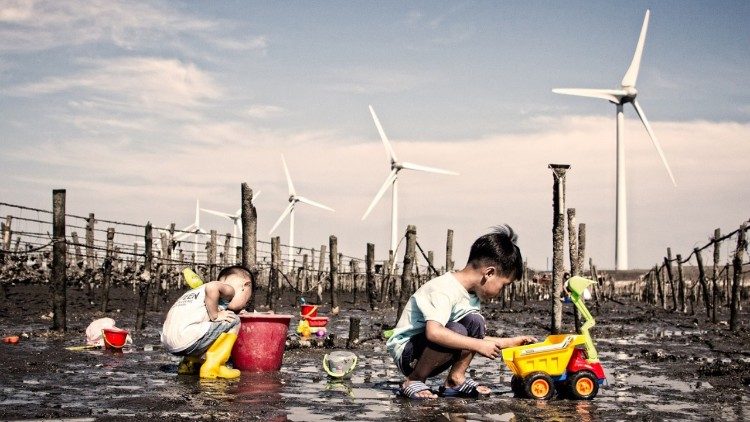 Children play near wind turbines