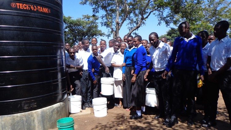 Sr. Bokamba with colleagues and students at one of the water project tanks in Mosanga, Tanzania