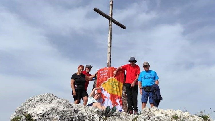 Pellegrini italiani all'inizio del cammino, sotto la croce sul Monte Lussari