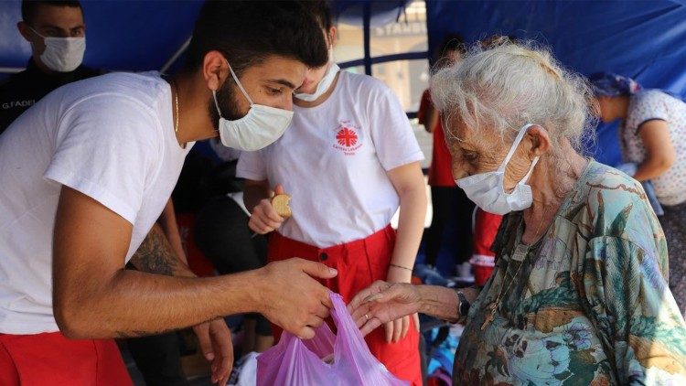 Assistenza ad un anziana da parte di giovani di Caritas Libano dopo l'esplosione al porto di Beirut