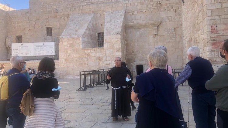 Pellegrinaggio francescano ai tempi della pandemia, la guida parla ai pellegrini all'esterno della Basilica di Betlemme