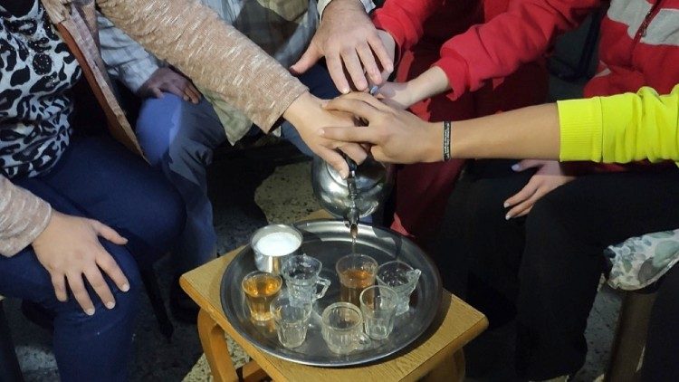 A displaced family of five in Damascus serving tea