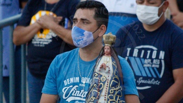 Joven paraguayo carga la imagen de Nuestra Señora de los Milagros de Caacupé