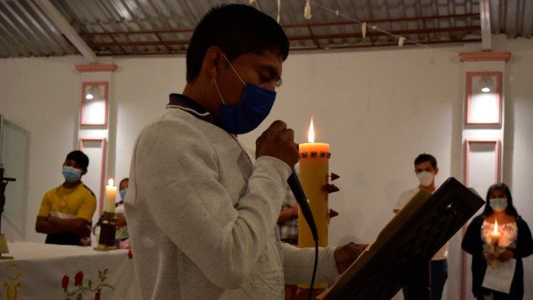 Un joven lee durante la liturgia de la Palabra de la Vigilia Pascual