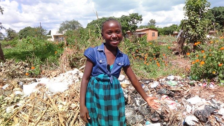 Una niña muestra la basura en la calle