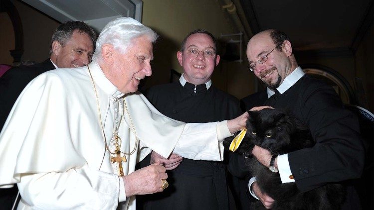 Benedicto XVI acaricia a un gato durante su viaje apostólico al Reino Unido en 2010.