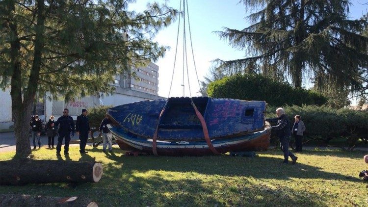 Un barcone viene adagiato nel giardino del carcere di Opera