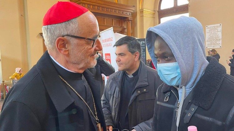 Il cardinale Czerny incontra un profugo nigeriano fuggito dall'Ucraina nella stazione Keleti di Budapest