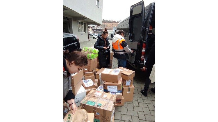Voluntarios rumanos descargan la ayuda que será transprotada hacia Ucrania
