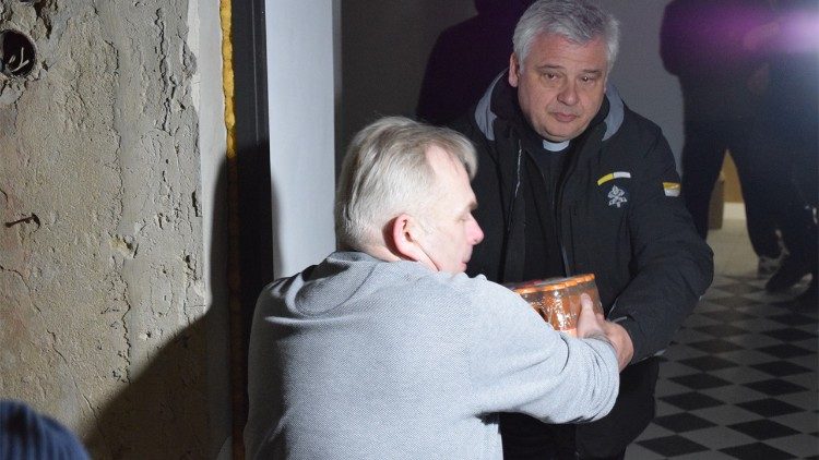 Кардинал Краевский разгружает гуманитарную помощь в центре "Каритас" на Украине