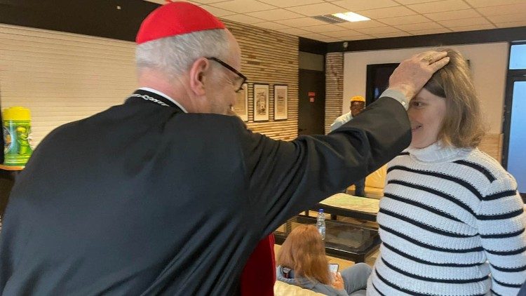 Il cardinale Czerny benedice una donna ucraina a Budapest, dopo la fuga dalla guerra