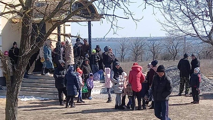 Les bénéficiaires des repas attendent devant l'église