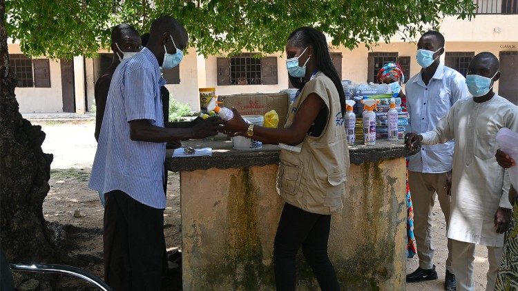 A teacher in Zadama, Nigeria, receives schol supplies and sanitizers from JRS (Credit: JRS International)