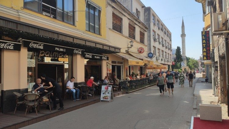Tavolini e gente a passeggio nel centro di Mostar