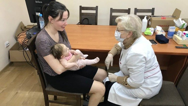 A displaced mother and child hosted by the Zarvanytsia Shrine visiting a doctor