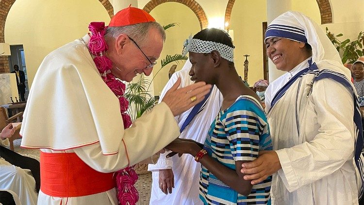 Cardinal Pietro Parolin greets a Congolese woman
