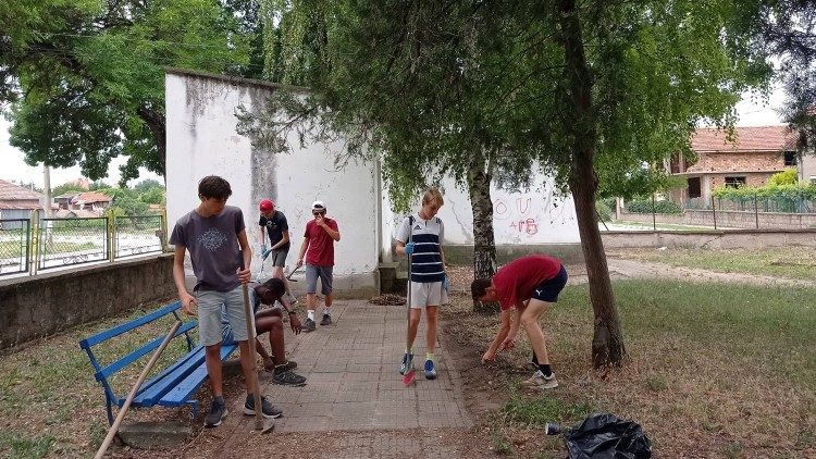 Giovani volontari ripuliscono un giardino pubblico