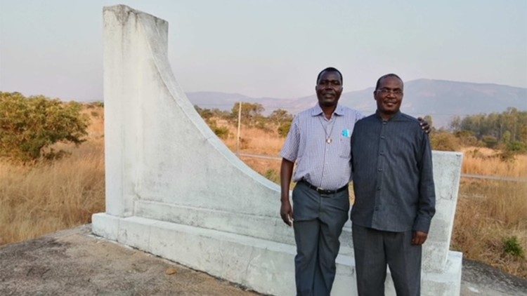 Padres Alberto Tchindemba e Gaudêncio Sangando, junto ao monumento aos mártires em Tchingenge (Angola)