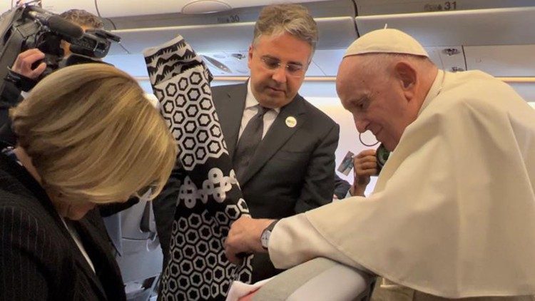 La periodista de Radio Cope, Eva Fernández, entrega un regalo al Papa en el vuelo hacia Kazajistán