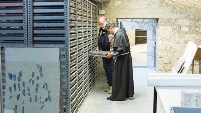 Padre Enzo Fortunato nel deposito dei frammenti degli affreschi della volta 