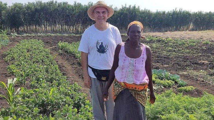 Le Père Antonio Peretta, avec une bénéficiaire, dans les champs du projet agro-pastoral à Mailana (Mozambique)