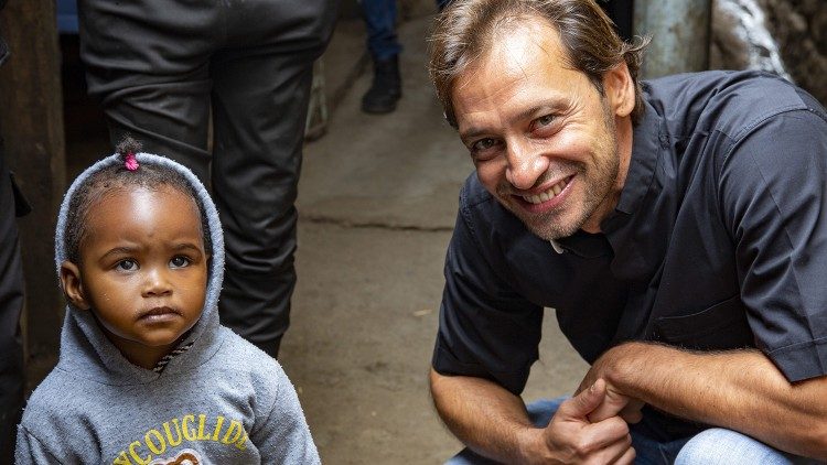 Davide Banzato con un bimbo durante le riprese in Kenya del suo programma "I viaggi del cuore"