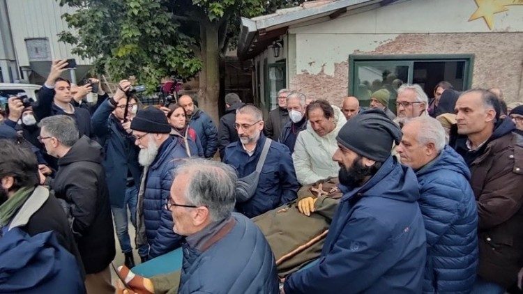 Il corpo di fratel Biagio lascia la stanza dove il missionario laico è morto per essere portato in chiesa. Padre Pino è il primo dei portantini a sinistra